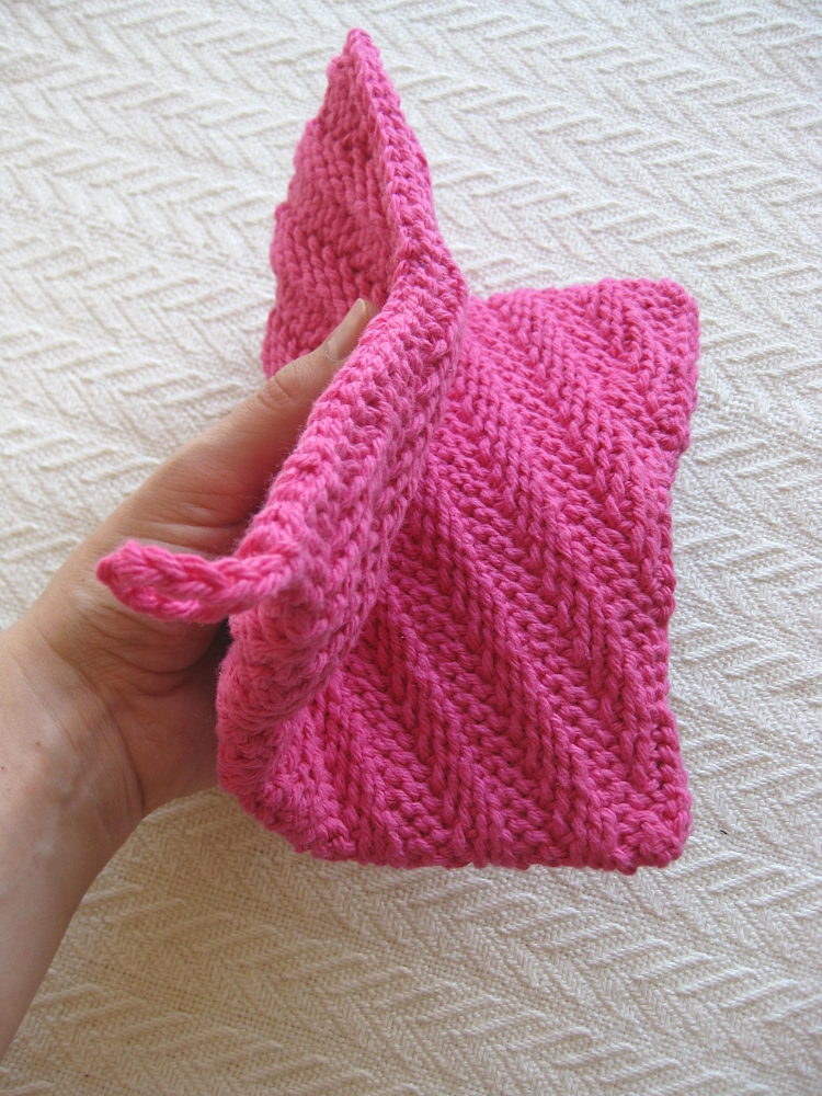 Woman's Hand Holding Pink Crocheted Potholder