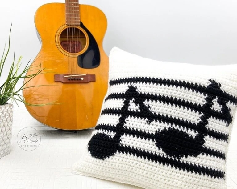 White pillow with black musical staff and two notes