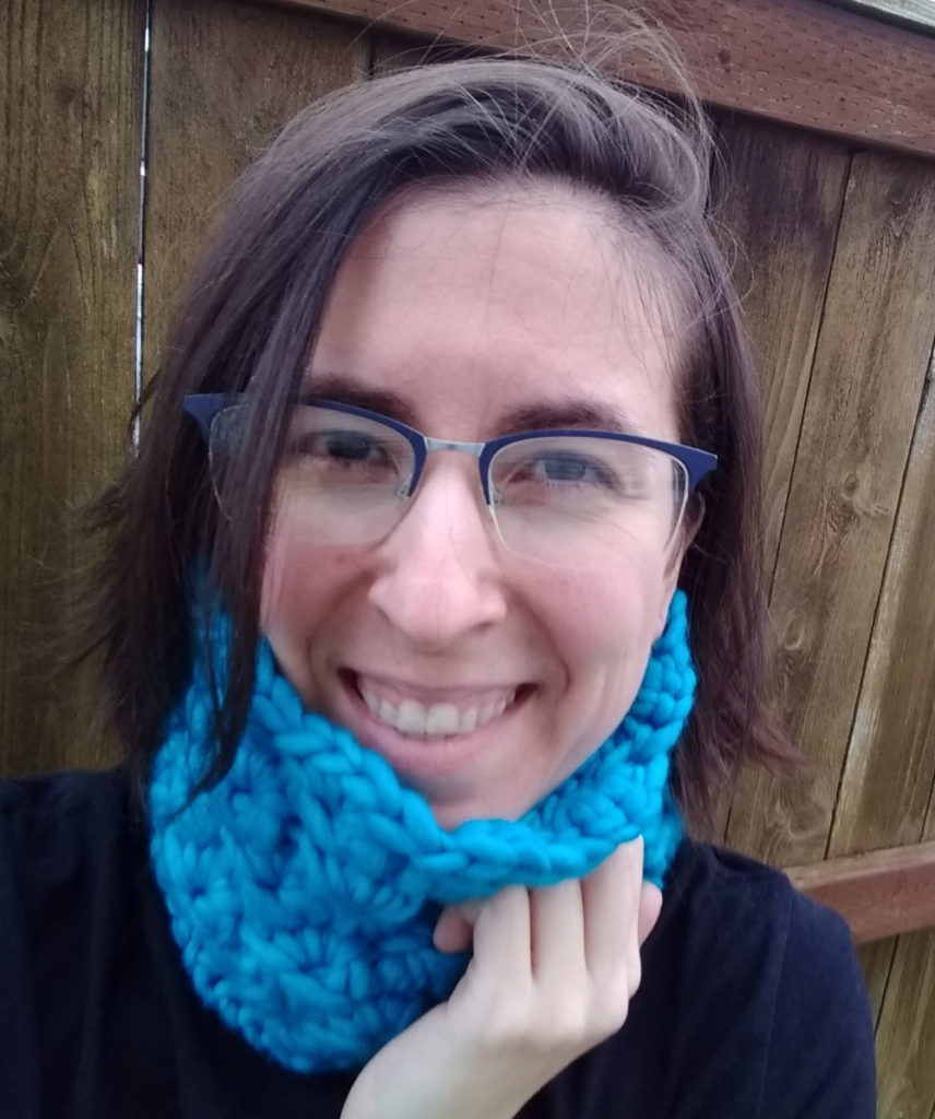 Woman wearing bright blue chunky crocheted broomstick lace neckwarmer